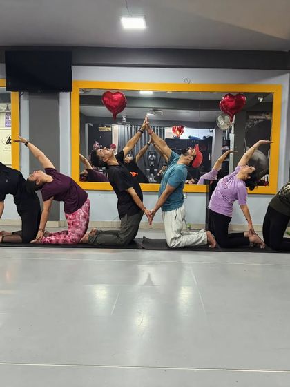 A creative group pose spelling out "OM". This is a beautiful way to end a session, combining physical practice with a shared spiritual intention.