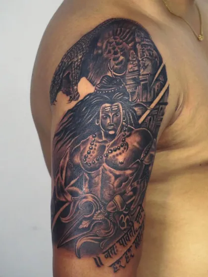 A powerful full-bicep tattoo of Lord Shiva in his warrior form. The background shows a temple and his loyal bull Nandi, creating a complete scene of divine power and devotion.