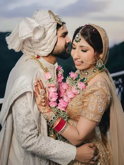 A tender moment between the couple against the backdrop of rolling green hills. The groom's gentle kiss on the bride's forehead captures the romance of their scenic wedding.
