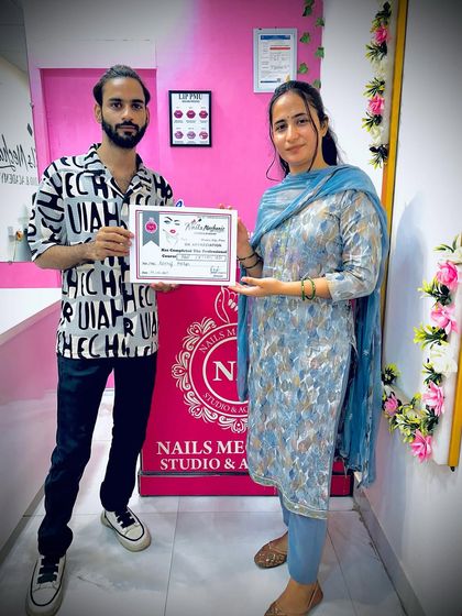 Presenting a certificate of completion to a dedicated student. She has mastered everything from basic prep to advanced art and is ready to start her career.