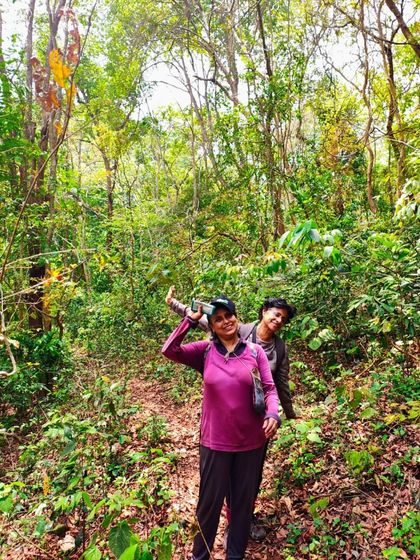 Trekkers walking through the dense forest trail on the way to the caves.