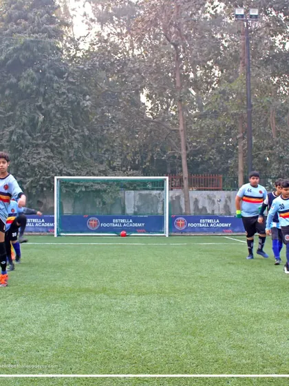Players go through dynamic warm-up routines, including high kicks and jogging, to prepare their bodies for an intense training session.