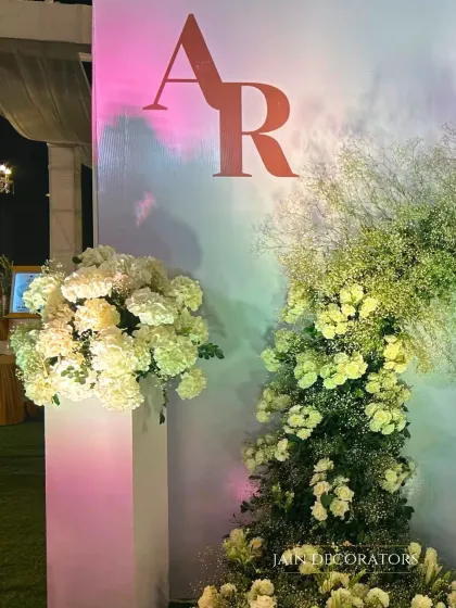 A modern and minimalist detail. The couple's monogram is set against a clean white wall, accented by dramatic arrangements of white hydrangeas and baby's breath.
