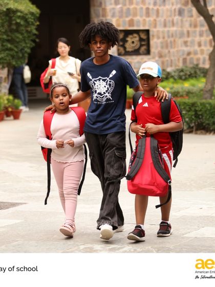 An older student walks with his younger siblings on the last day of school. AES is a community for the whole family, where students across all grade levels feel connected and supported.