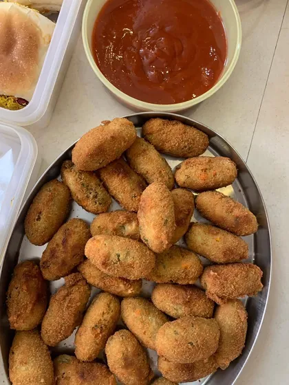 Crispy veg croquettes served with ketchup, a classic party snack.