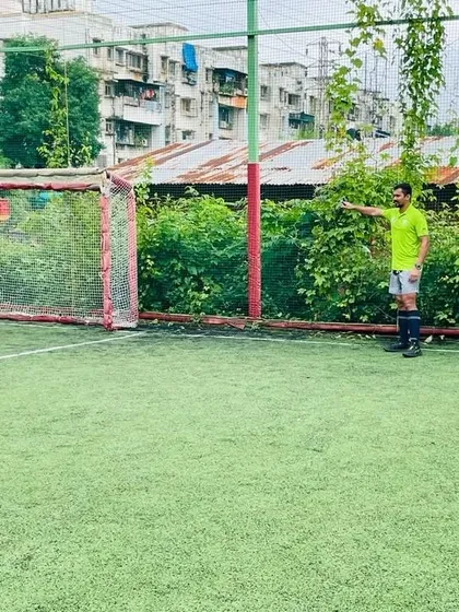 A coach observes the game, ready to provide feedback. Our coaching staff is always engaged and monitoring player performance.