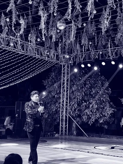 A solitary moment on stage, mic in hand. This artistic shot reflects the responsibility and the presence required to hold the attention of a large audience.