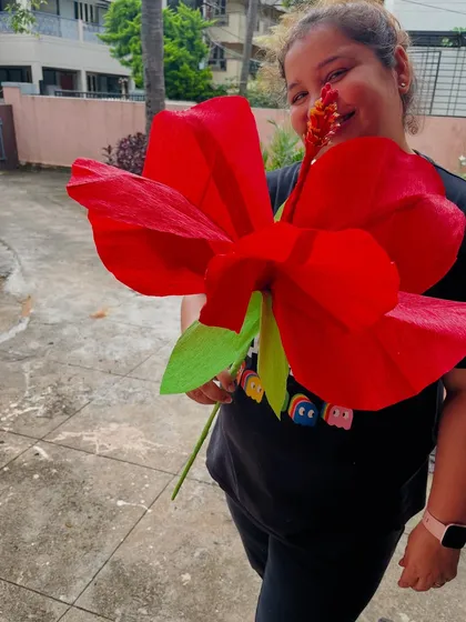Here I am with a giant paper hibiscus we created. These large-scale paper flowers are perfect as photo props for events, unique party decor, or even as a statement piece for a wedding backdrop.