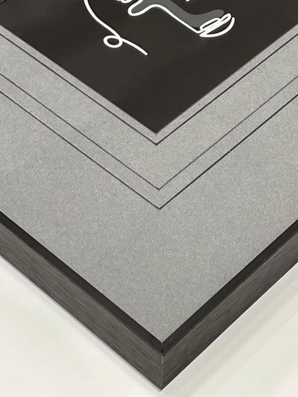 A close-up detail of the corner, showing the clean lines of the V-groove and the contrast between the grey mats and the black metal frame.
