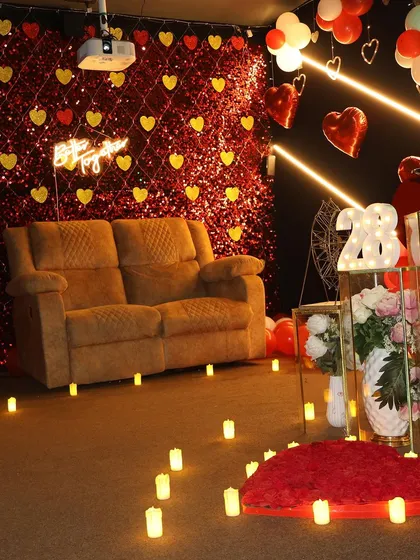 This romantic setup features a candle-lit path, a heart made of rose petals, and a sparkling backdrop. It's the perfect ambiance for an anniversary or a birthday celebration for your special someone.