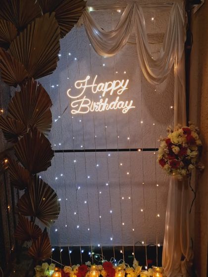 The balcony setup at night, creating a warm and intimate atmosphere for a romantic birthday celebration.