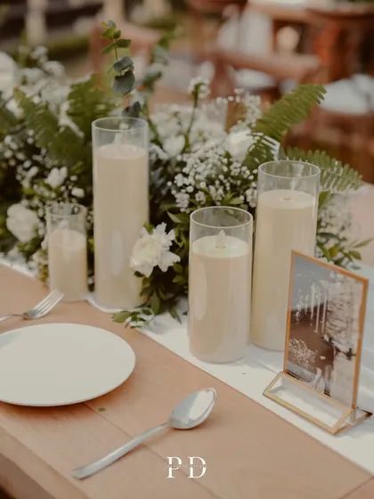 A close-up of the centerpiece, featuring pillar candles and a small framed photo of the couple. It's these personal touches that make a celebration unique.