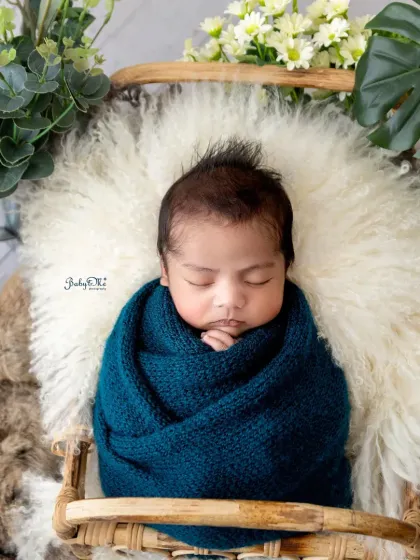 A beautiful overhead shot of a swaddled newborn, showing the perfect wrap and their peaceful expression. I love using rich, deep colors to create a warm and vibrant feel.