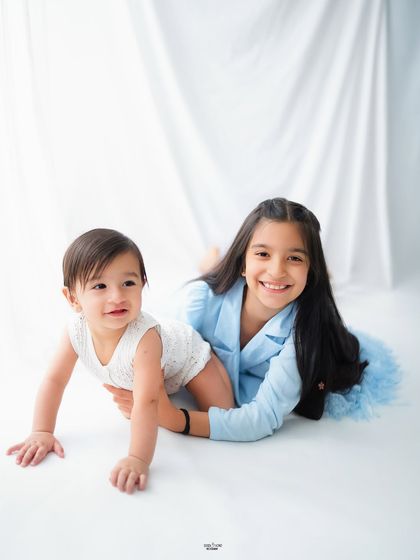Big sister helping her little sibling learn to crawl. I love capturing these sweet, unposed interactions during a family session.
