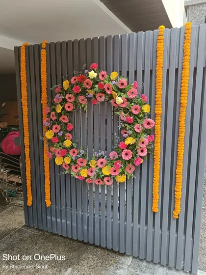 A simple yet beautiful way to welcome guests is with a decorated gate. For this entrance, I created a large wreath from fresh, colorful gerbera daisies and framed it with traditional marigold flower strings, or genda phool ladi.