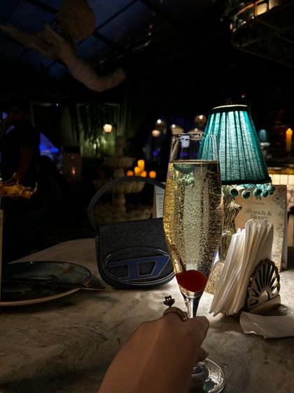 A glass of champagne at a beautiful, dimly lit bar.