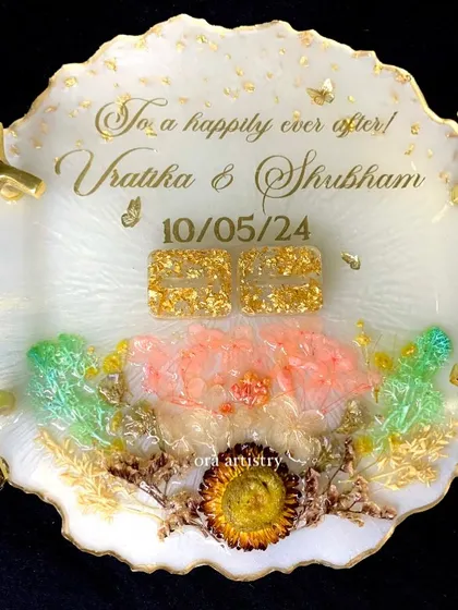 A close-up of a beautiful engagement ring platter, showing the intricate details of the preserved flowers and gold accents.
