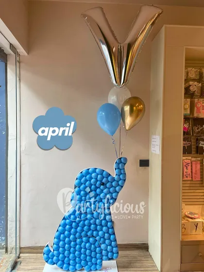 This adorable blue elephant sculpture, holding a bouquet of balloons in its trunk, is a perfect welcome piece for a baby shower or a child's birthday party.