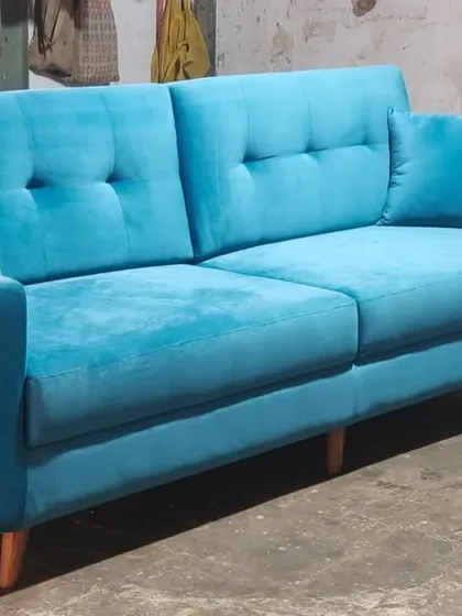 Another custom-made sofa in a bright blue velvet fabric. This design features tufted back cushions and solid wood legs, showcasing the variety of styles I can create.