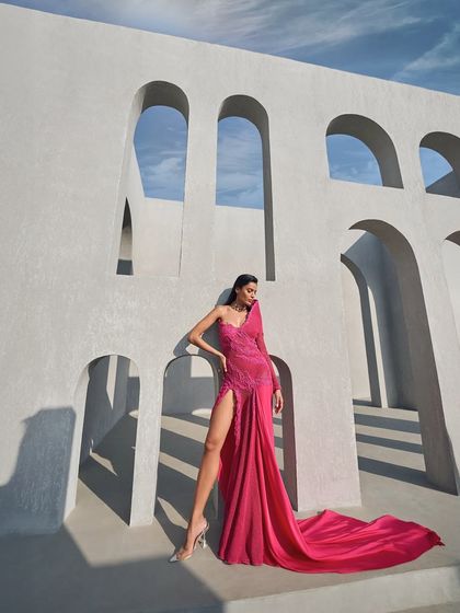 The unveiling of a vivid hue from my 'Prismatic Symphony' collection. A structured one-shoulder silhouette in hot pink, balanced by a fluid drape and a thigh-high slit.