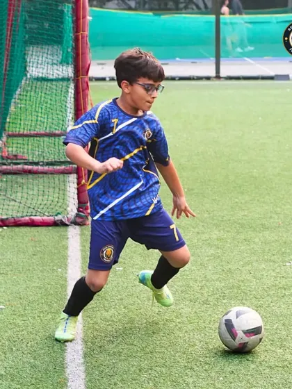 A young midfielder scans the field, ball at his feet, looking for the best option. This demonstrates the game awareness and decision-making skills we cultivate.