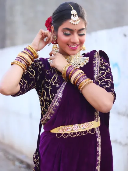 The bride adjusting her earring, a classic pose that highlights her jewelry and makeup.