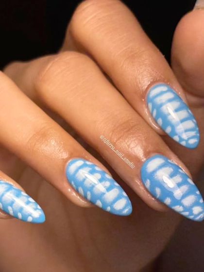 A full hand view of the stunning blue and white patterned nails.