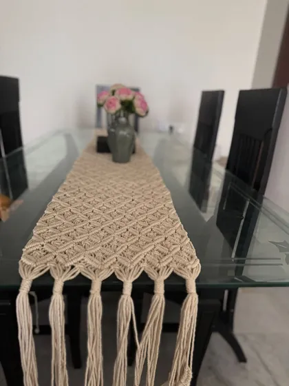 Our macrame-style table runner, adding a touch of texture and bohemian elegance to a modern glass dining table.