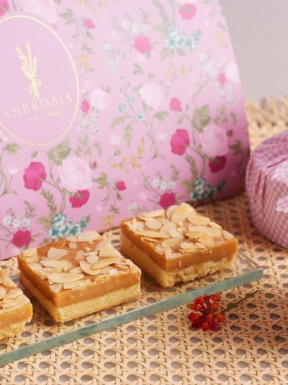 A close-up of our almond teacakes with our signature pink packaging in the background, showcasing the elegance of our gifting options.