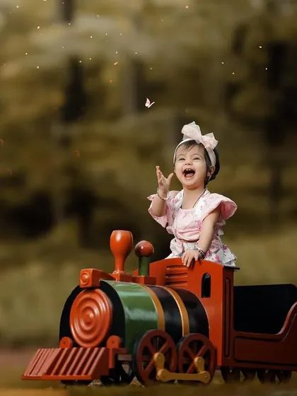 Reaching for the magic. This shot captures a little girl's wonder as she tries to catch a butterfly from her perch on the toy train.