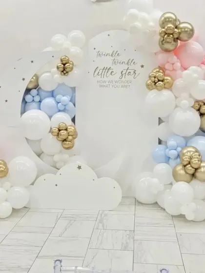 The 'Twinkle Twinkle Little Star' theme is a wonderful choice for a gender-neutral baby shower or a gender reveal party. This clean and dreamy design uses a moon-shaped backdrop, cloud cutouts, and a mix of pastel pink, blue, white, and chrome gold balloons.