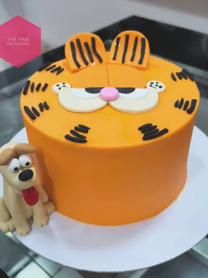 A fondant cake featuring the classic cartoon cat, Garfield, with his friend Odie. The bright orange color and grumpy expression are captured perfectly.