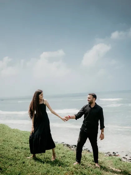 A playful and interactive shot of the couple on the Alibag coast. The bright sky and blue sea provide a stunning backdrop for this happy moment.