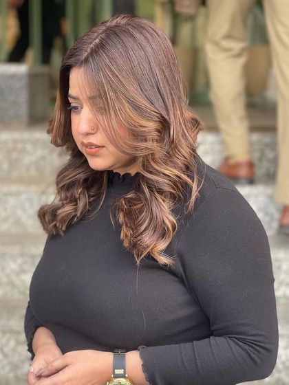 Another angle of the cool brown balayage, showing how the color frames the face and adds dimension. The soft curls enhance the blend of cool and neutral tones.