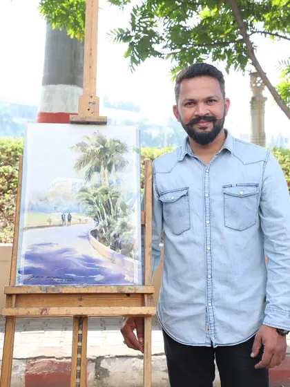 Standing with the completed landscape painting after the workshop at D.Y. Patil College.