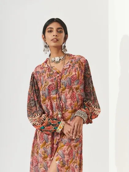 A model in a bohemian-style printed dress. The makeup is natural and earthy, with a focus on warm tones and a healthy glow, ideal for a relaxed, outdoor wedding function.