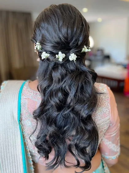A simple and elegant half-updo with a few fresh flowers.