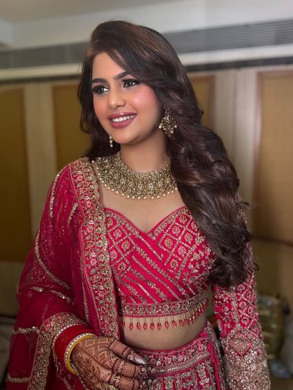 A beautiful portrait of Megha ready for her reception. The look is classic and glamorous, with soft curls and a warm, glowing makeup palette.