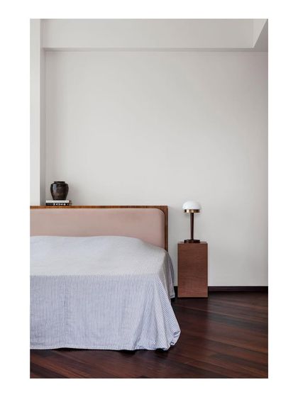 This bedroom is a study in repose and stillness. The custom bed and integrated nightstand are crafted with clean lines and warm wood, creating a simple, peaceful sleeping environment.