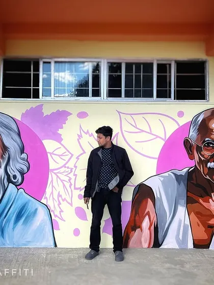 Standing in front of my portraits of Rabindranath Tagore and Mahatma Gandhi. Part of the 100-foot mural in Ziro, these pieces were painted with great respect to honor their contributions.