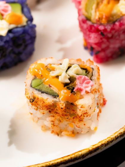 A close-up of a single Avocado Asparagus Tempura roll, showcasing its intricate details.