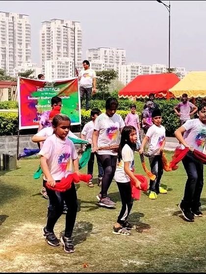 Students using colorful props during their Holi dance, adding to the festive and playful atmosphere of the performance.