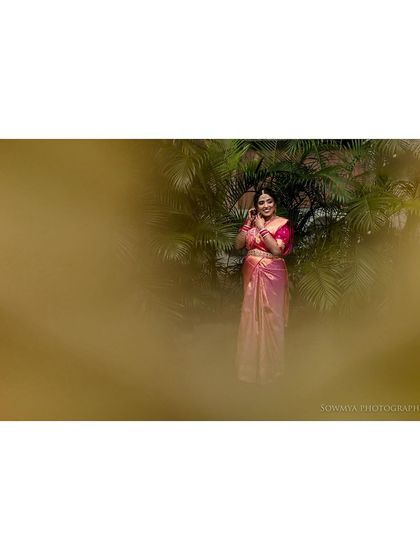 A bride framed by a soft, out-of-focus foreground, creating a dreamy and intimate portrait.