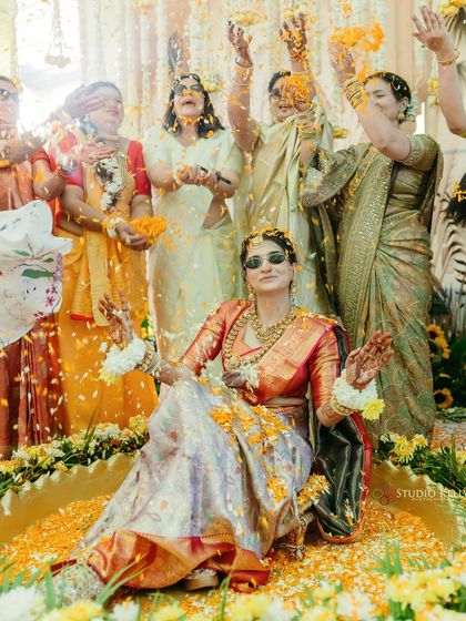 The bride enjoys a flower shower during her Haldi ceremony, a vibrant and joyful moment captured perfectly against the backdrop of Rajasthan.