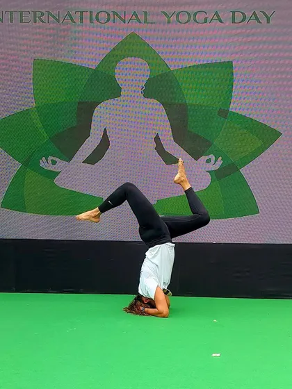 Holding a steady headstand pose during the International Yoga Day celebration. This asana represents focus and balance, two key elements that yoga helps cultivate in our daily lives.
