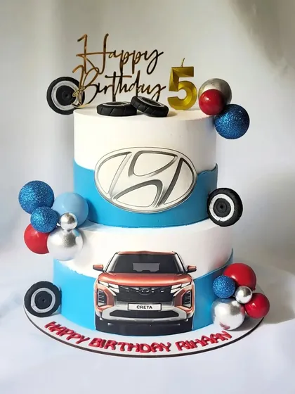 This two-tier cake was designed for a car enthusiast, featuring the Hyundai logo and an edible image of the Creta. It's a great example of incorporating brand elements into a personal celebration cake.