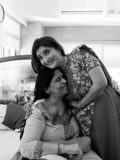 A touching black and white photo of the bride sharing a warm hug with an elder family member. A beautiful moment of love and blessings.