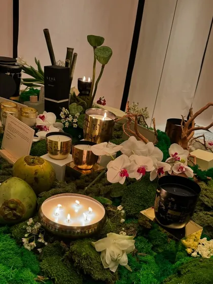 For a product launch, I dressed the table with a bed of green moss, white orchids, and other natural elements like coconuts and lotus pods. The style is Indian with an international flair, creating a sophisticated and earthy display.
