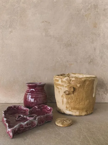 A collection of finished pieces with rich, varied glazes, showing the beauty that comes from the fire.