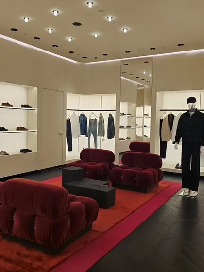 The ready-to-wear section of the Valentino store is designed as a luxurious lounge. Plush, sculptural red sofas create a bold color statement and offer a comfortable, intimate space for clients to relax and engage with the collection.
